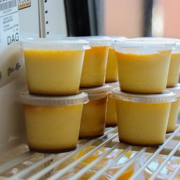 Rows of Tom's Cuban on the Go flan desserts in clear plastic cups with lids.